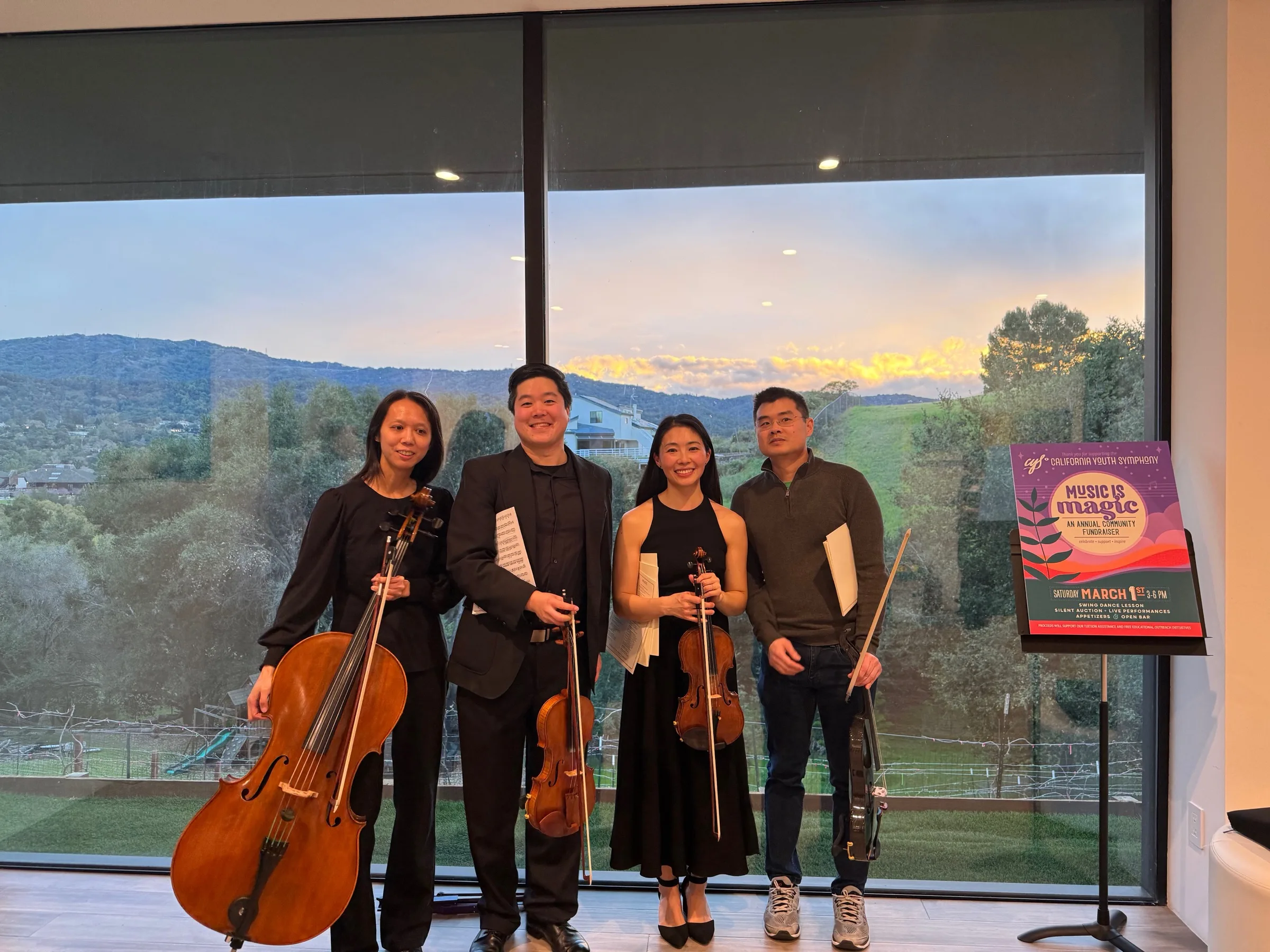 Lumon Quartet standing with their instruments in front of a sunset after a performance